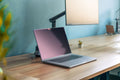 Wooden two-tier desk shelf with laptop on a warm wood desk