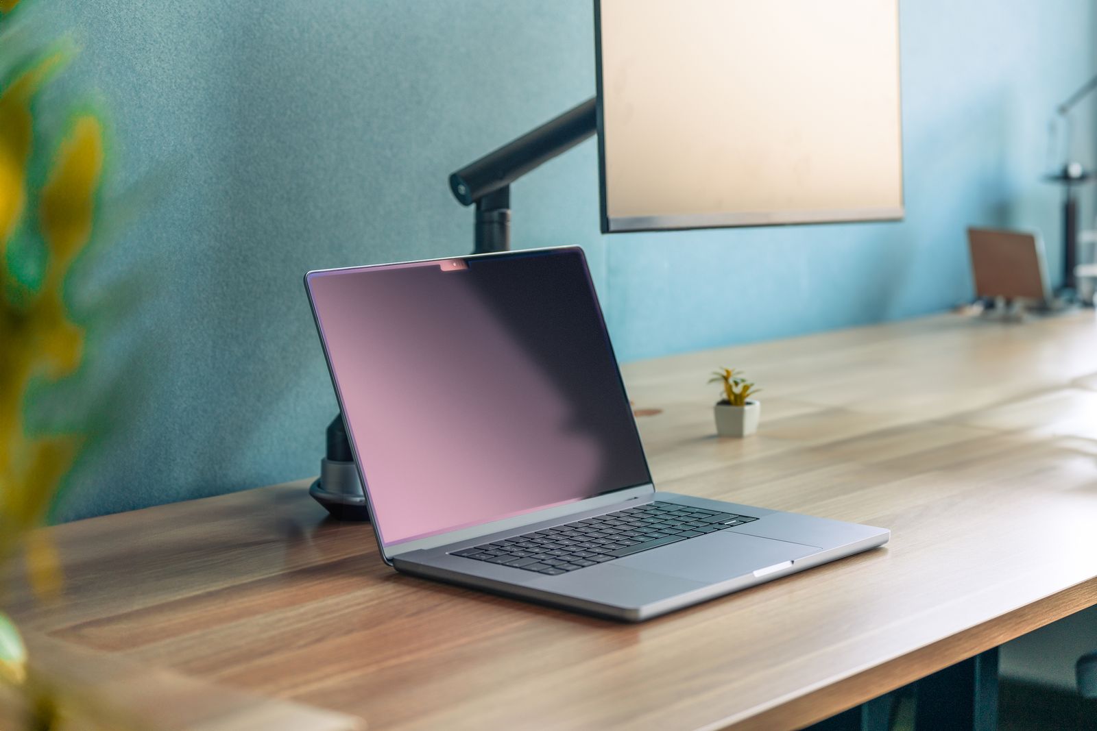 Wooden two-tier desk shelf with laptop on a warm wood desk
