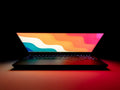 Vertical laptop stand holding closed MacBook on side